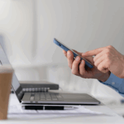A business person at the work desk with a laptop and a smartphone